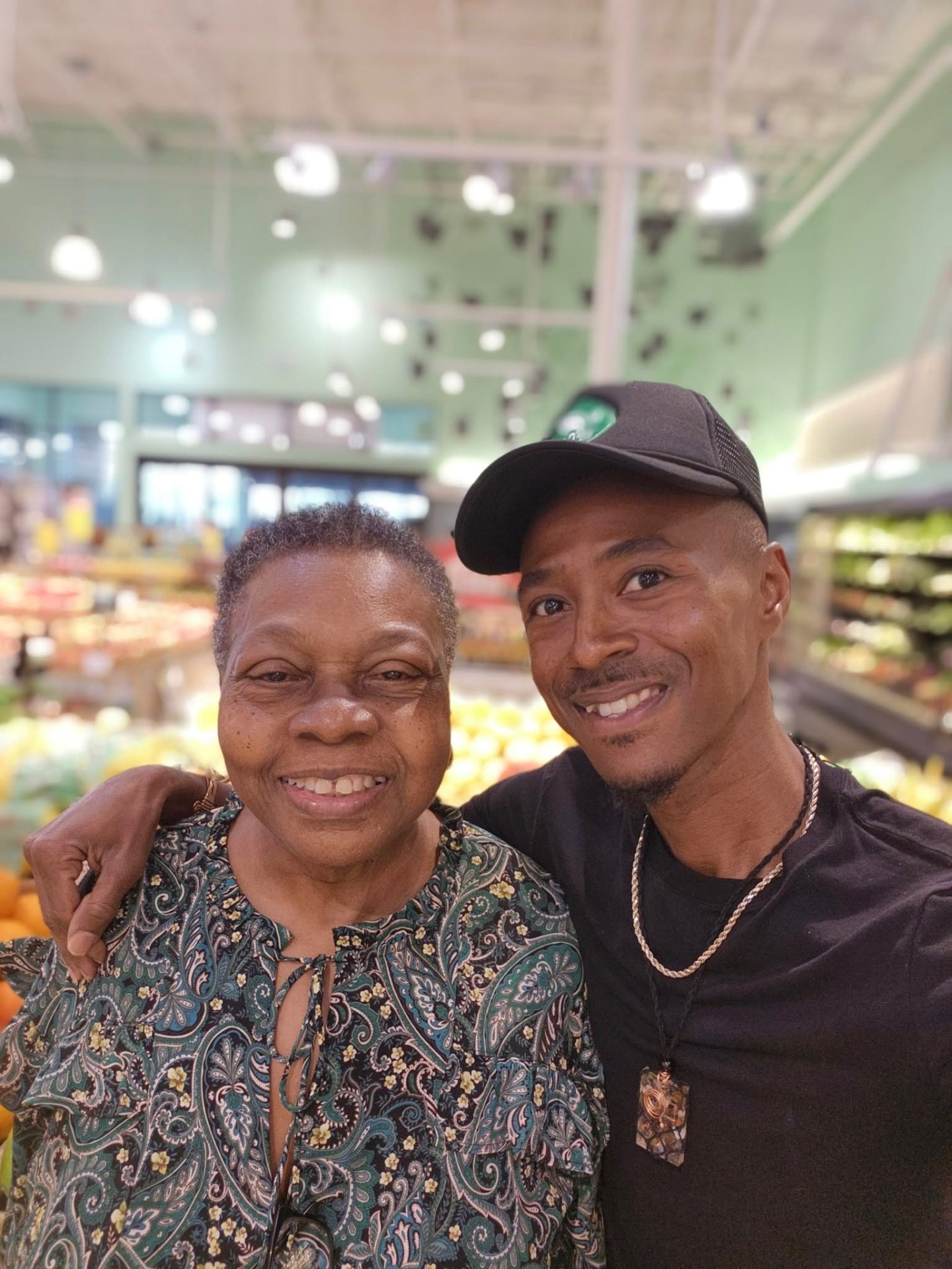 Marcus with a smiling community member in the produce aisle